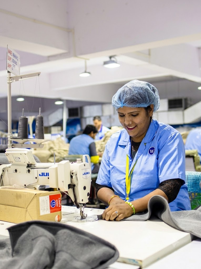 Factory workers operating sewing machines on a textile production floor